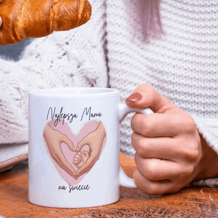 Kubek z grafiką serca, w środku ręce mamy i dziecka. Napis Najlepsza Mama na świecie
